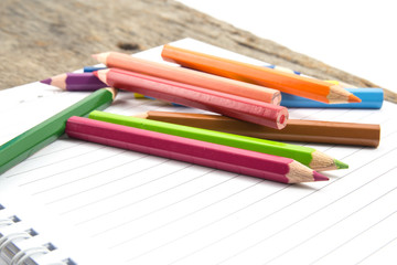 Blank paper and colorful pencils on the wooden table.