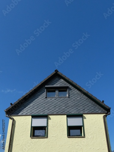 "Fassade mit gelbem Putz und Schindeln aus grauem Schiefer" Stockfotos