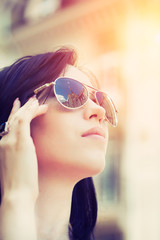 Fototapeta na wymiar beautiful young woman wearing sunglasses on a city street