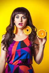 beautiful young woman wearing earrings made from orange and hold