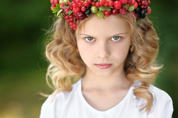Naklejka premium portrait of a beautiful little girl with berries