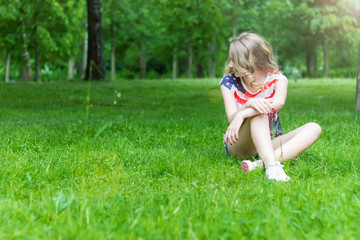 young girl is smiling and happy sitting on the grass