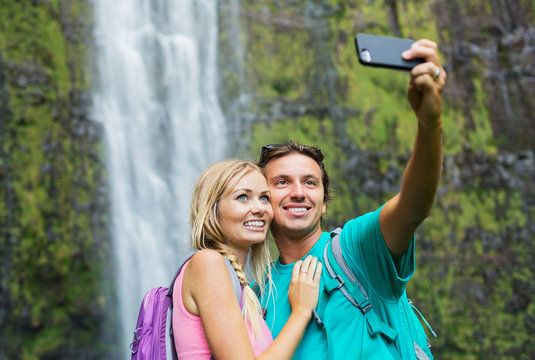 Couple having fun taking pictures together outdoors on hike