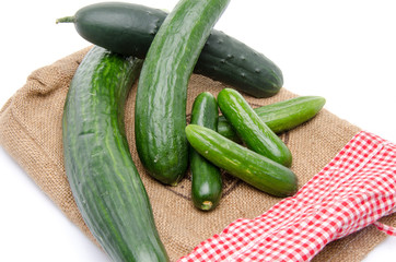 Fresh long and mini cucumbers on burlap