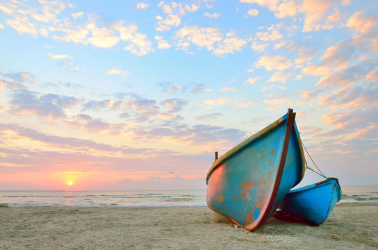 Fototapeta blue fishing boat at sunrise