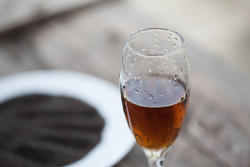 Glass of cognac with Dry sweet basil seed standing on a wooden t