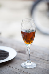 Glass of cognac with Dry sweet basil seed standing on a wooden t