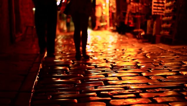 People walking on dark street.