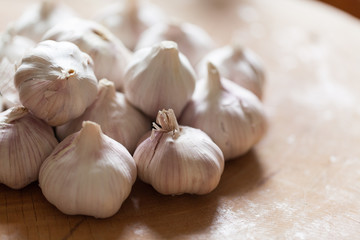 a clove of garlic and a whole wooden table closeup