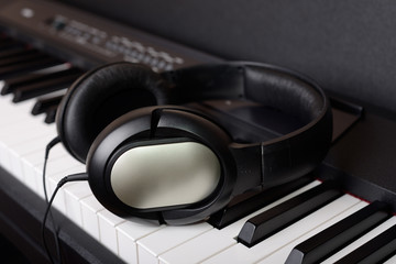 Obraz na płótnie Canvas Close-up headphones on piano keyboard