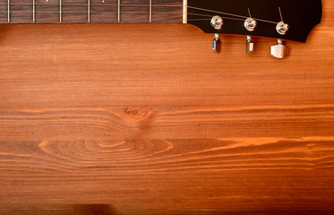 Close-up western guitar neck on wooden background