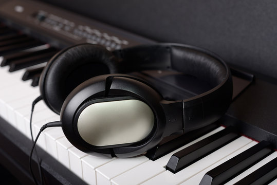 Close-up headphones on piano keyboard