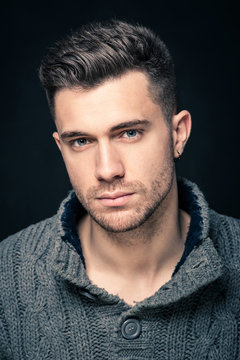 Man close up intense portrait against dark background.