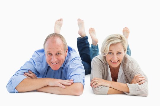 Happy mature couple lying and smiling