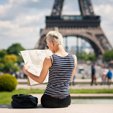 Young blonde woman looking at map of the city in front of the Ei