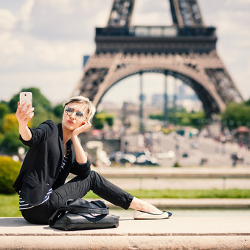 Happy young woman taking a selfie with mobile phone in Paris, Fr