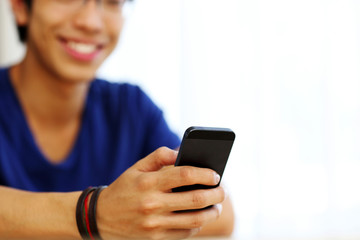 Closeup portrait of a man using smartphone. Focus on smartphone