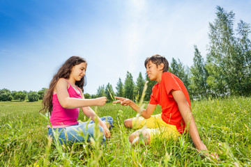 Children play rock-paper-scissors on grass