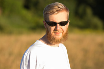 Young smiling bearded man in sunglasses