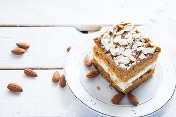 Piece of almond cake. Composition on white wooden board