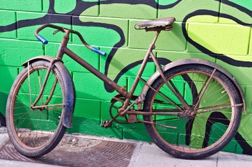 Fototapeta na wymiar old bike against grafitti wall