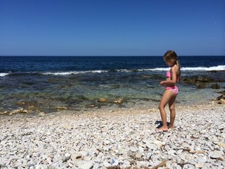 Spiaggia di pietre e bambina