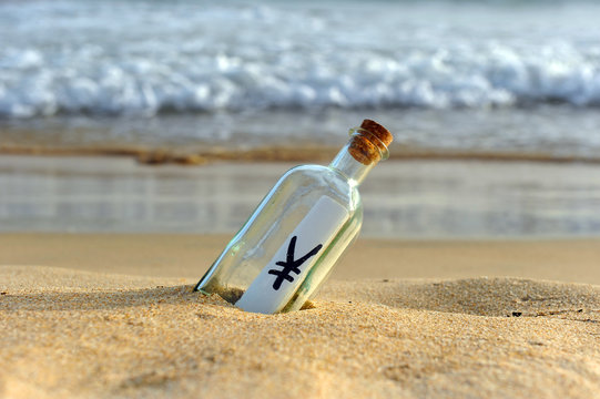 Yen, currency of Japan in a bottle on the beach