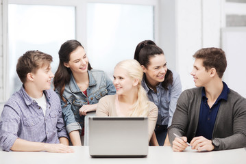 smiling students with laptop at school