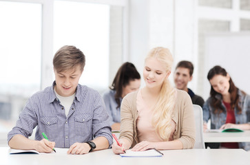 two teenagers with notebooks at school