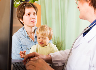 Obraz premium woman with baby listening doctor at clinic