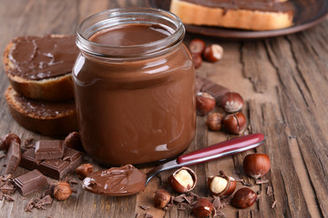 Sweet chocolate cream in jar on table close-up