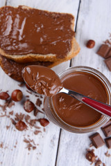 Sweet chocolate cream in jar on table close-up