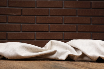 Wooden table with cloth on wall background