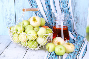Ripe apples and juice in basket on table close-up