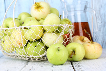 Ripe apples and juice in basket on table close-up