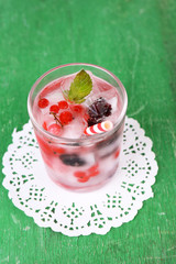 Cold cocktail with forest berries, frozen in ice cubes