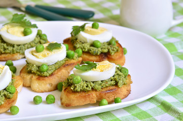 Toasts with basil pesto,eggs and green peas.
