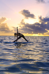 woman doing yoga on a paddle board