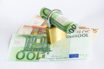Euro Geldschein gerollt mit Vorhaengeschloss auf Geldscheinen
