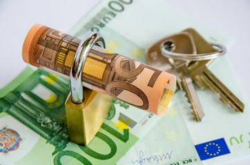 Euro gerollt mit Schloss und Schluessel auf Banknoten