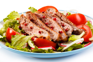 Grilled meat and vegetables on white background