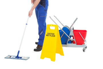 Low Section Of Servant Mopping Floor By Wet Floor Sign