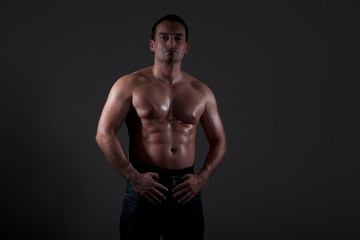 Fototapeta na wymiar Muskulöser Mann Oberkörper mit dunklen Licht Porträt