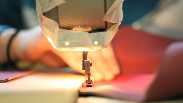 hands sewing machine in a factory manufacturing leather