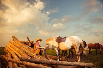 cowboy with horses at farm sunset
