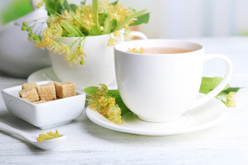 Tasty herbal tea with linden flowers on wooden table