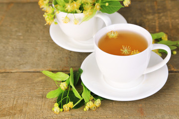 Tasty herbal tea with linden flowers on wooden table