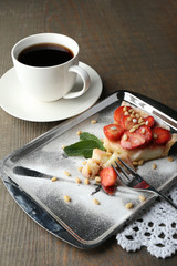 Piece of strawberry tart on  tray, on rustic wooden background