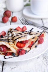 Delicious pancakes with berries on table close-up