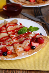 Delicious pancakes with berries on table close-up